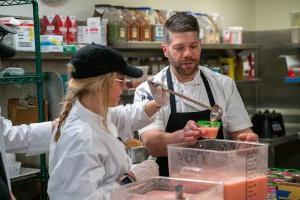 Hospitality management students at Northwood University participating in a kitchen lab where they are making juice